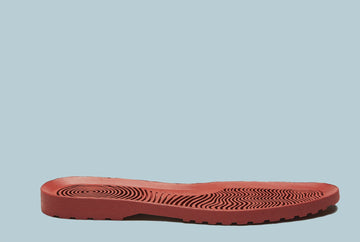 red sole of a shoe on a blue background